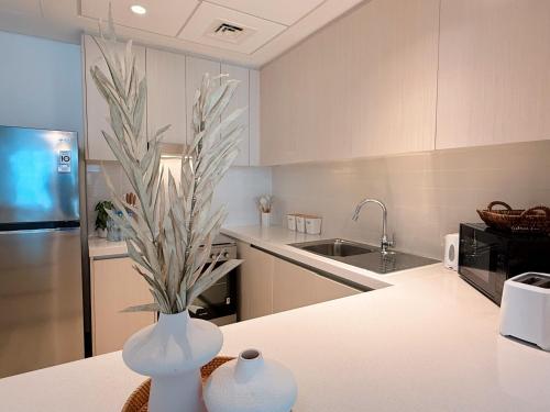 a kitchen with a vase with a plant in it at 2 Bedroom In Waters Edge Voyage in Yas Island
