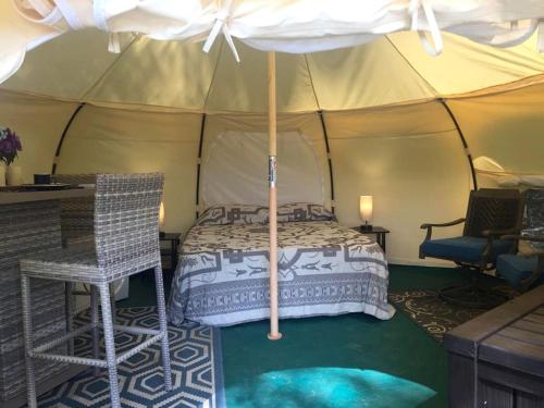a bedroom in a tent with a bed and chairs at Glamping Getaway on an Impressive Farm near Charlottesville, Virginia in Gordonsville