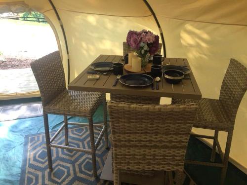 a table and chairs in a tent with a table and flowers at Glamping Getaway on an Impressive Farm near Charlottesville, Virginia in Gordonsville