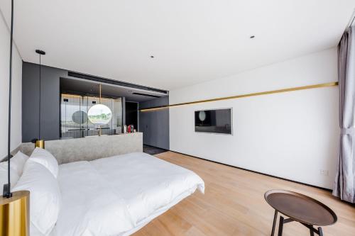 a bedroom with a large white bed and a chair at the house of mo in Shanghai