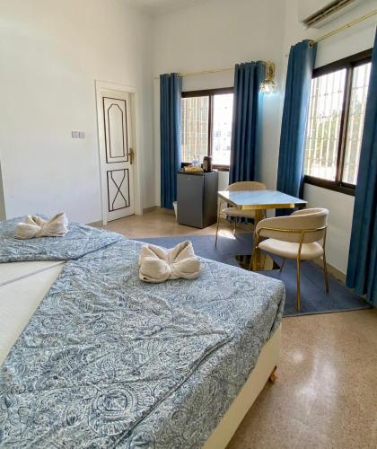 a bedroom with two beds and a table and chairs at Arabian Nights Nook in Muscat