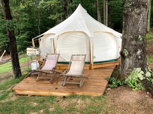 a tent with two chairs and a wooden deck in front at Fantastic Virginia Glamping Retreat near Charlottesville in Gordonsville