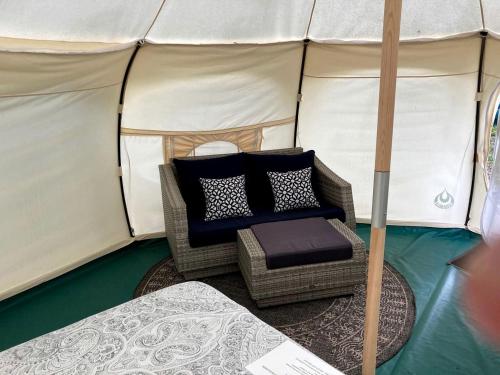 a wicker chair and pillow in a tent at Gorgeous Virginia Retreat on a Farm with Spectacular Views in Gordonsville
