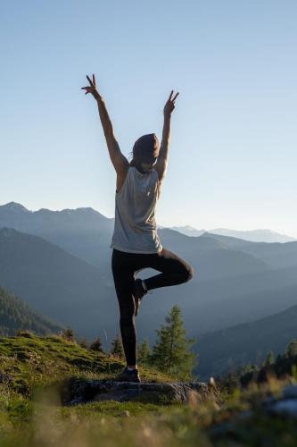 a woman doing a yoga pose on top of a mountain at Berg-Leben in Grossarl