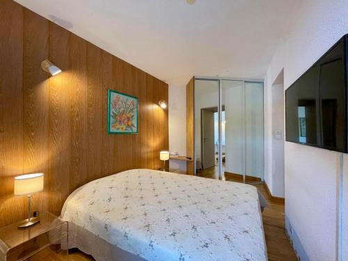 une chambre avec un grand lit et une télévision dans l'établissement Le Sunset, à Andernos-les-Bains