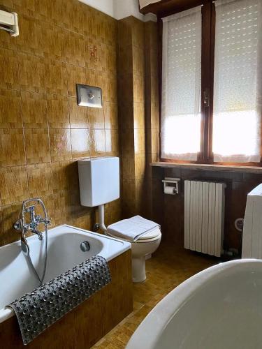 a bathroom with a bath tub and a toilet at Casa Gaia - Vicino a Gardaland e Lago di Garda in Cavalcaselle