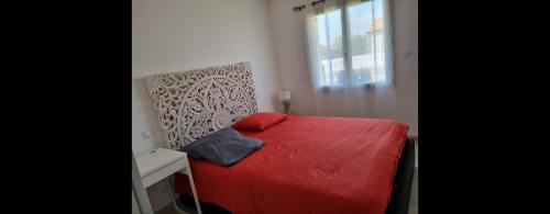 - une chambre avec un lit rouge et une fenêtre dans l'établissement Chambre Relax Détente, à Vairé