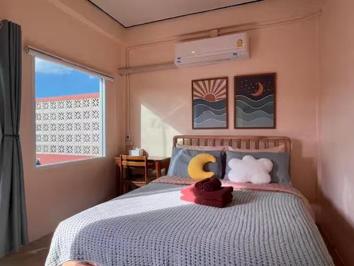 a bedroom with a bed with a stuffed animal on it at Papaya House Bangkok - Wat Arun in Bangkok Noi