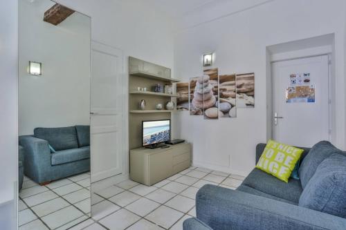 un salon avec un canapé bleu et une télévision dans l'établissement MARI 117 - Nice City Center, à Nice