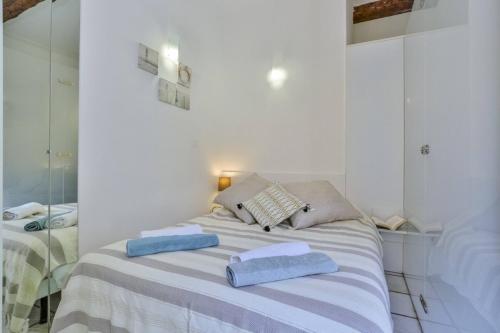 - une chambre blanche avec un lit et 2 serviettes dans l'établissement MARI 117 - Nice City Center, à Nice