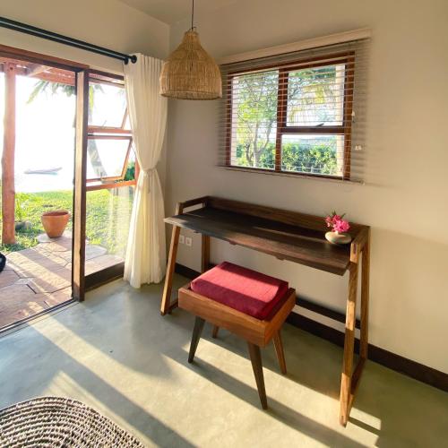 a room with a desk and a bench and a window at Casa Babi in Vilanculos