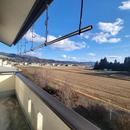 a view of a field from the balcony of a house at Guesthouse & Sharehouse カリマ安曇沓掛 in Omachi