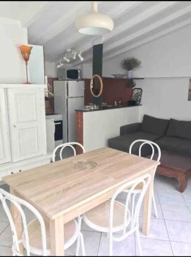 une table et des chaises en bois dans un salon dans l'établissement Appartement Villa Lucie, à Leucate