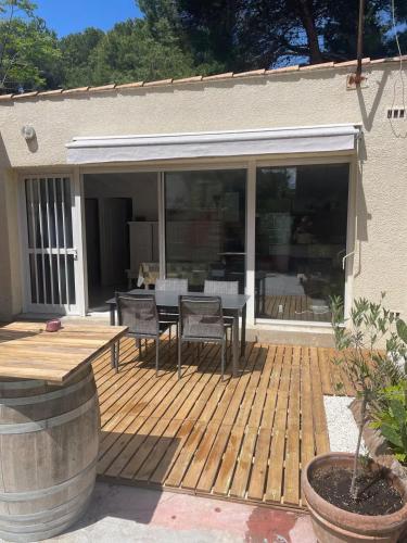 une terrasse en bois avec une table et des chaises. dans l'établissement Appartement Villa Lucie, à Leucate