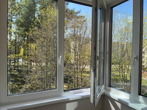 a room with three windows looking out at trees at Gero laiko oazė in Visaginas