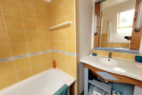 une salle de bain avec une baignoire et un lavabo dans l'établissement Maison Belle Dune L'Ile Aux Oiseaux 28, à Quend-Plage
