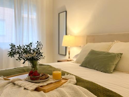 a bed with a tray of fruit and orange juice at ChillaHomes 004 in Candeleda