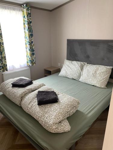 a bedroom with a bed with two towels on it at Chalet 4 personen HZ 18 in Lauwersoog