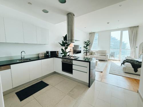 a kitchen with white cabinets and a stove top oven at Studio In Al Bandar Hosted By Voyage in Abu Dhabi