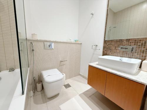 a bathroom with a toilet and a sink and a shower at Studio In Al Bandar Hosted By Voyage in Abu Dhabi