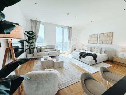 a living room with white furniture and a large window at Studio In Al Bandar Hosted By Voyage in Abu Dhabi