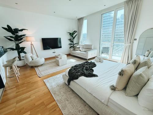 a living room with a large bed and a television at Studio In Al Bandar Hosted By Voyage in Abu Dhabi