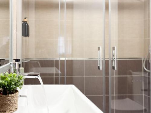 a bathroom with a shower with a sink and a tub at ChillaHomes 004 in Candeleda