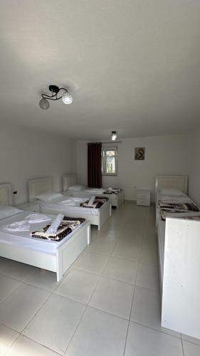 a room with four beds in it with a window at Bujtina Brahim Selimaj in Valbonë