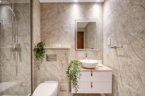 a bathroom with a sink and a toilet and a shower at The Smart Concierge - Delphine in Dubai