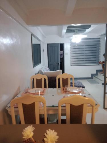 a dining room with a table and chairs and a couch at Casa Cecilia in Lipa