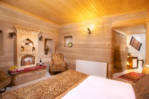 a bedroom with a bed and a chair and a fireplace at Lord of Cappadocia Hotel in Goreme