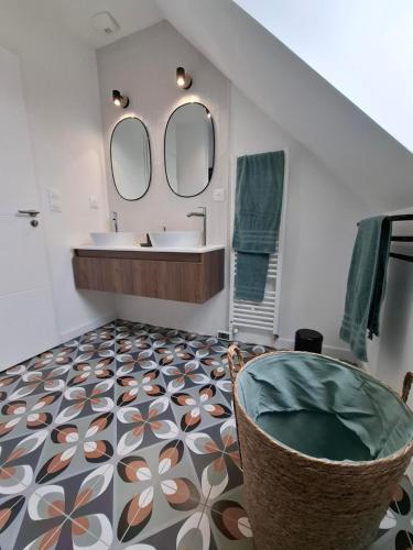 une salle de bain avec un lavabo et deux miroirs dans l'établissement La villa'gapanthe, à Sarzeau