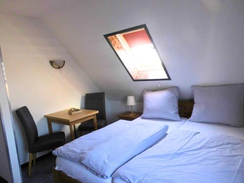 a bedroom with a bed and a table with a chair at Küstenlounge Dornumersiel in Dornum