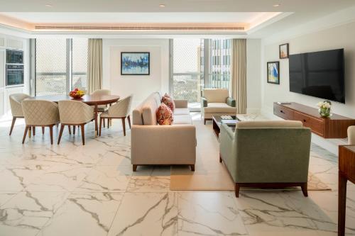 a living room with a table and chairs and a television at Cheval Maison - Expo City Dubai in Dubai