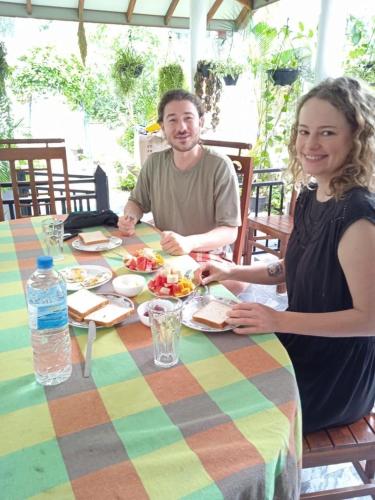 a man and woman sitting at a table eating food at The Shilpa Villa in Unawatuna