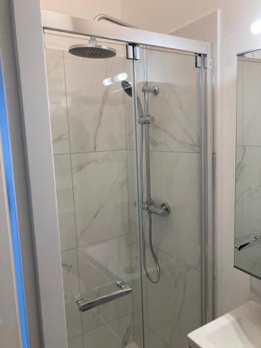 une douche avec une porte vitrée dans une salle de bain dans l'établissement Evasion Marine 3, à Palavas-les-Flots