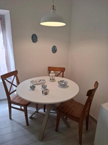 a dining room table with two chairs and a white table at Casa Emma in Chiavari