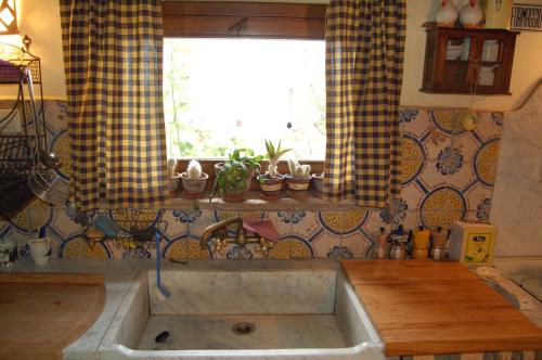 a kitchen with a large sink and a window at Casale La Quercia in Pian D'artino