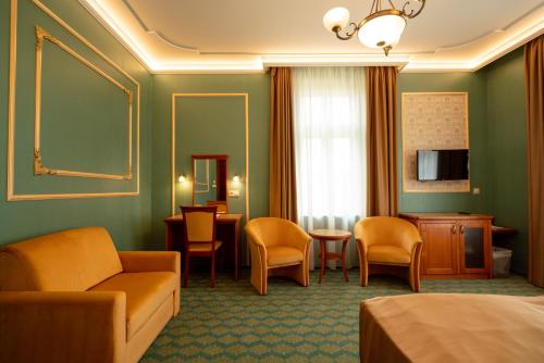a hotel room with a bed and a table and chairs at Elizabeth Hotel in Gyula