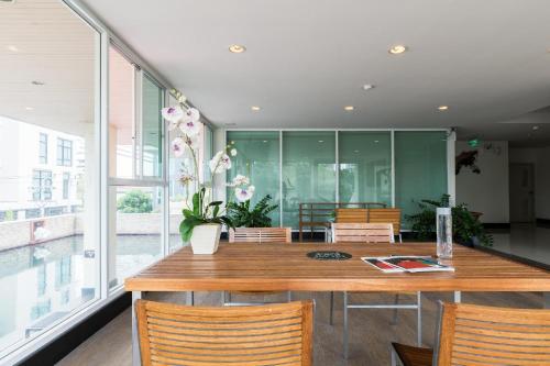 a dining room with a wooden table and chairs at Bangkok Patio BTS Sanam Pao in Bangkok