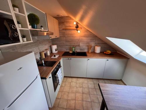 a kitchen with white cabinets and a sink at Private & Comfortable Apartments in Puttelange-aux-Lacs