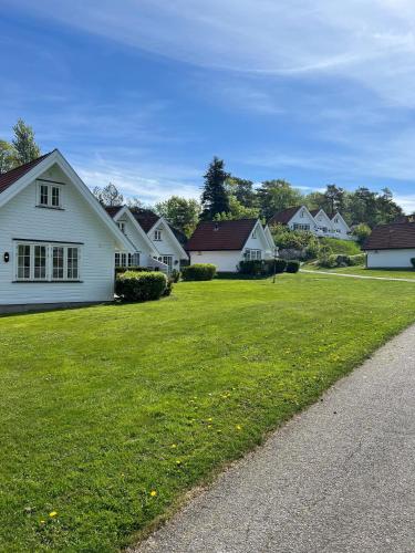 a group of white houses on a green lawn at Havna Tjøme Hotel in Tjøme
