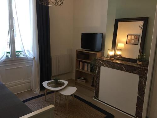 - un salon avec une télévision et un miroir dans l'établissement Le Cosy Studio Hyper-centre, à Orléans
