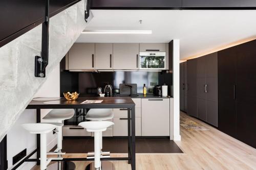 une cuisine avec des armoires en noir et blanc et une table dans l'établissement B4 Loft Duplex 175Blo-Paris Convention, à Paris