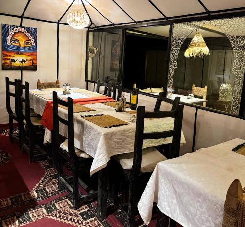 a dining room with a table and chairs and a mirror at Outdoor luxury camp in Merzouga