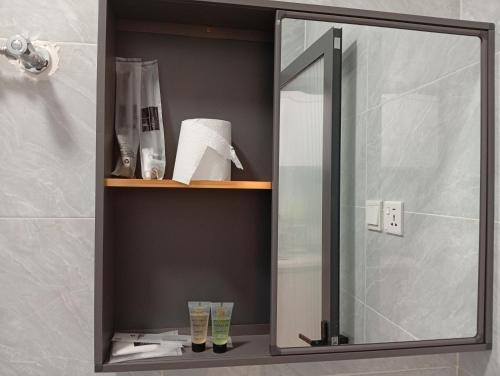 a bathroom with a mirror and a shelf with towels at Cozy homes sabaki in Nairobi