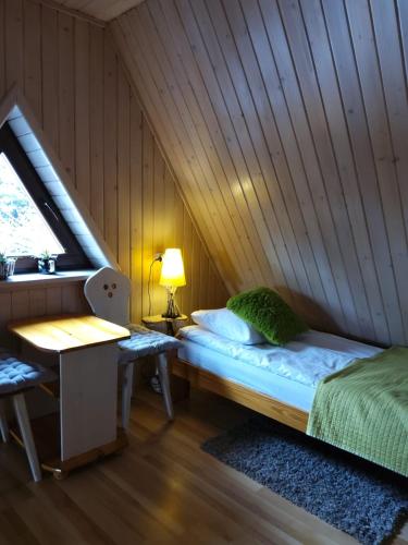 a room with a bed and a desk in a attic at Natura Bukowina Tatrzańska in Bukowina Tatrzańska