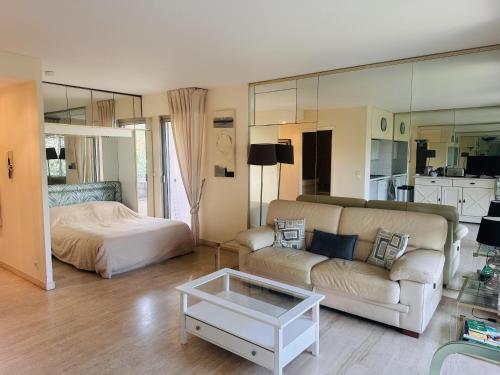un salon avec un canapé et un lit dans l'établissement Light modern Studio with Garden terrace shared pool - 2294, à Cannes