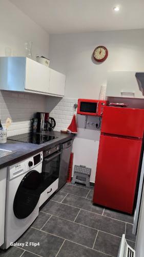 Il comprend une cuisine équipée d'une cuisinière et d'un réfrigérateur rouges. dans l'établissement Studio neuf avec terrasse, à Saint-Pierre-Quiberon
