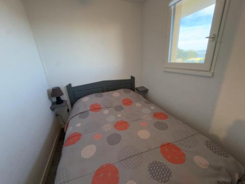 un petit lit dans une chambre avec une fenêtre dans l'établissement Les Barcarelles résidence entre montagne et mer, au Barcarès